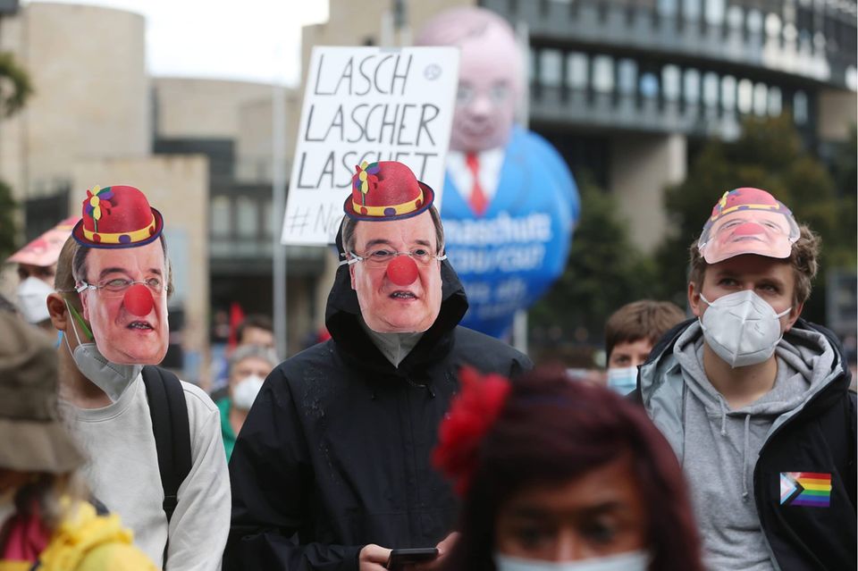 Demonstranten mit einer Armin-Laschet-Maske, Jecken-Hut und roter Nase stehen vor dem nordrhein-westfälischen Landtag. Zu der Klimademonstration hatten nordrhein-westfälische Ortsgruppen der Fridays-for-Future-Bewegung und Umweltverbände aus NRW aufgerufen.