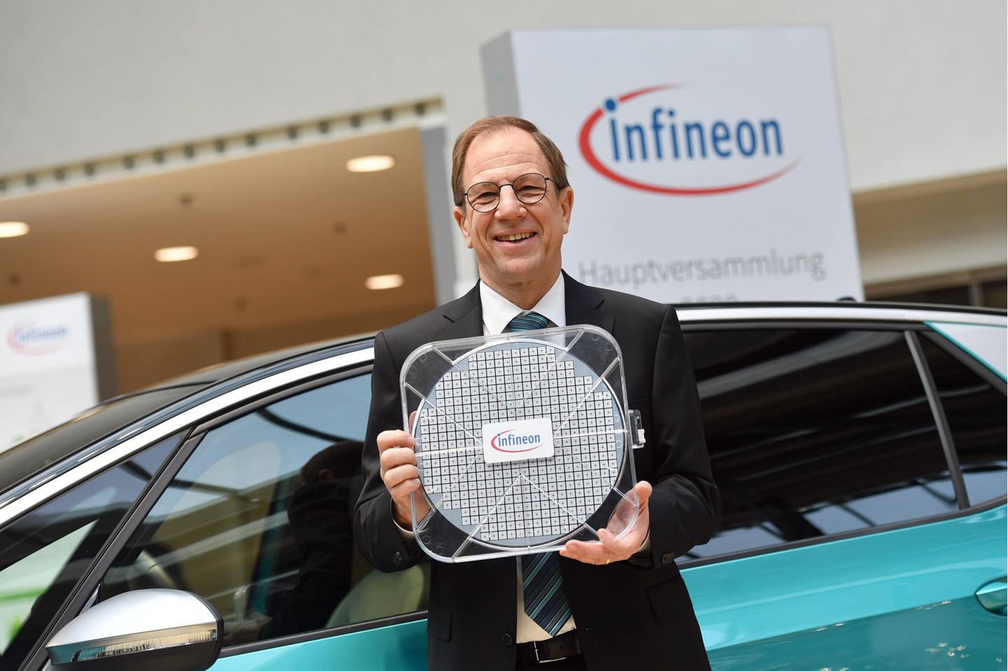 Dr. Reinhard Ploss Vorsitzender des Vorstands, posiert mit einem 30cm Waver Halbleiter an einem VW id3 E-Auto. Einzelbild,angeschnittenes Einzelmotiv,Halbfigur,halbe Figur. Hauptversammlung INFINEON Technologies AG am 20.02.2020 im ICM in Muenchen. *** Dr Reinhard Ploss Chairman of the Board, poses with a 30cm Waver semiconductor on a VW id3 E car single image, cut single motif, half figure, half figure Annual General Meeting INFINEON Technologies AG on 20 02 2020 at the ICM in Munich