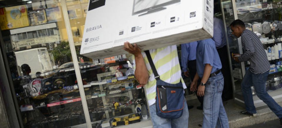 Reiche Beute: Ein Venezolaner trägt ein großes Paket aus einem Elektronikgeschäft