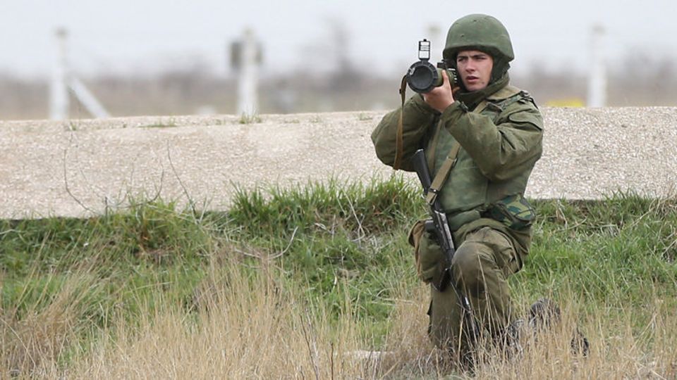 Ein russischer Soldat richtet seine Waffe gegen eine Gruppe Ukrainer