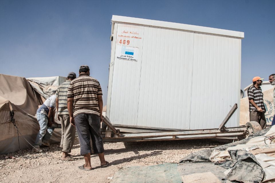 Im Lager gibt es Dienstleister wie überall auch. Hier sieht man eine Umzugsfirma - die allerdings gleich einen ganzen Wohncontainer umsetzt. Die Wohncontainer wurden von Saudi-Arabien gestiftet und sind inzwischen begehrte Handelsware