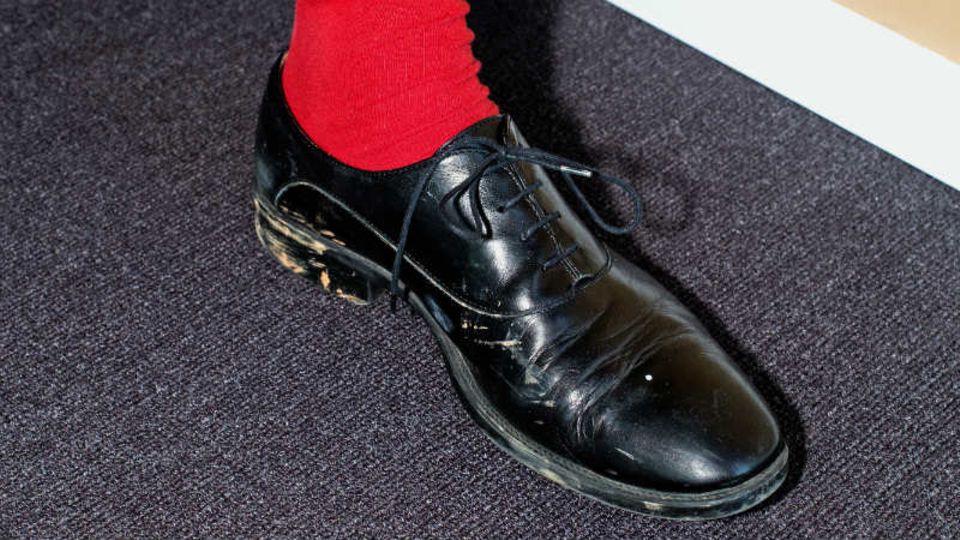 Das tut weh: rote Socken zu verschmutzten schwarzen Schuhen