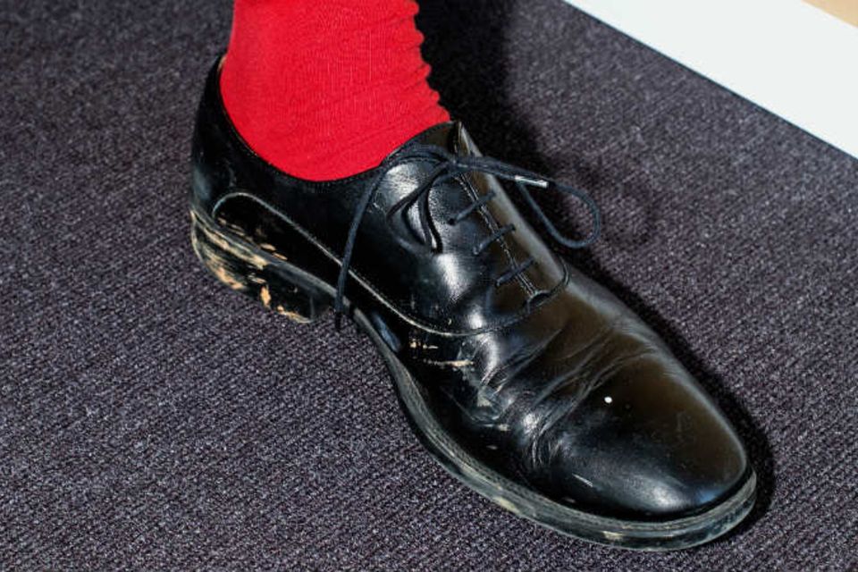Das tut weh: rote Socken zu verschmutzten schwarzen Schuhen