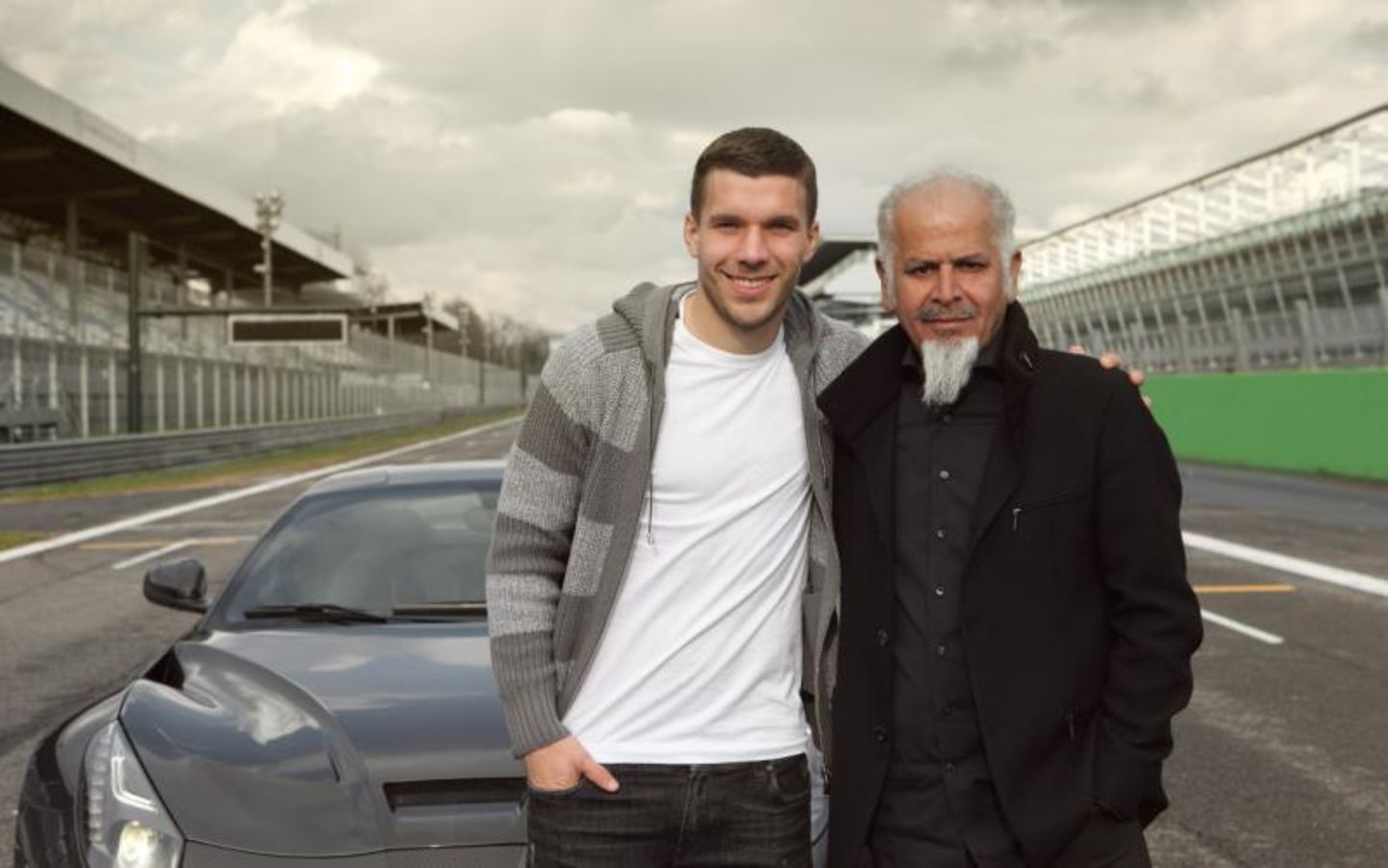 Lukas Podolski mit Kourosh Mansory vor seinem getunten Ferrari