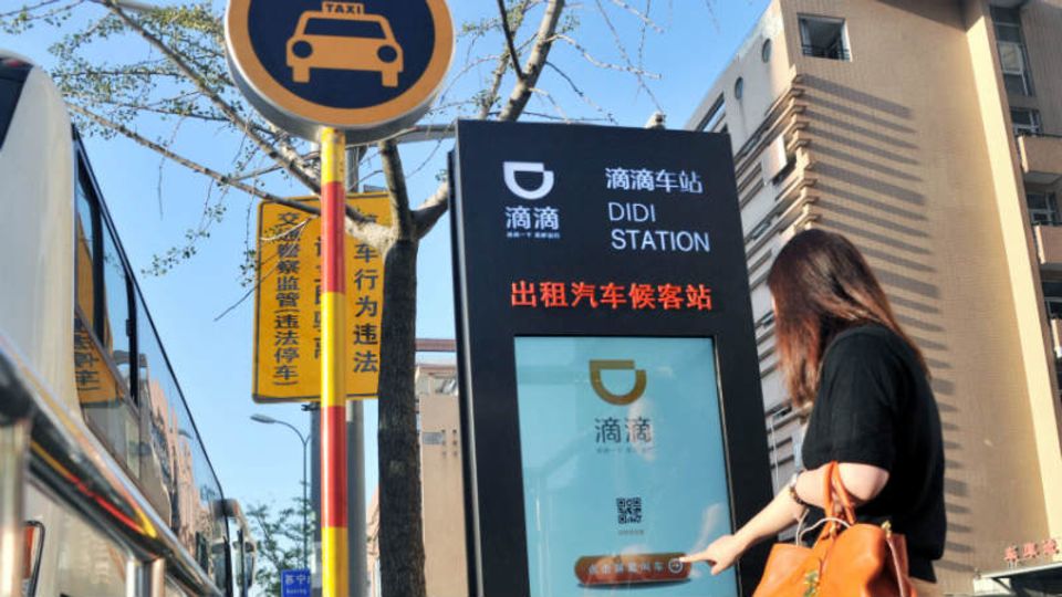 Teil der Infrastruktur: An einer Pick-up-Station in Schanghai ordert eine Frau einen Didi-Wagen