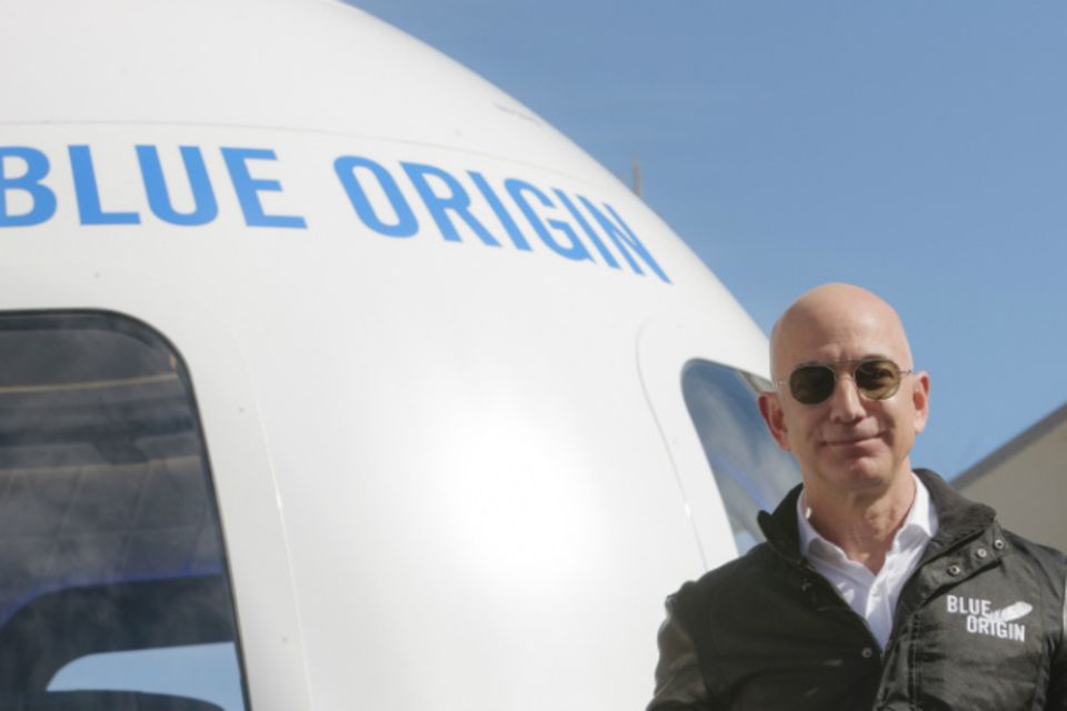 Jeff Bezos posiert vor einer Raumkapsel seiner Firma Blue Origin