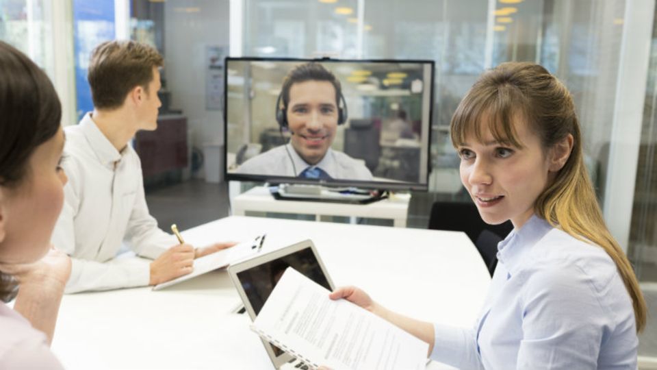 Teamsitzung mit einem zugeschaltenen Mitarbeiter: Die Zusammenarbeit in virtuellen Teams ist nicht immer ganz einfach
