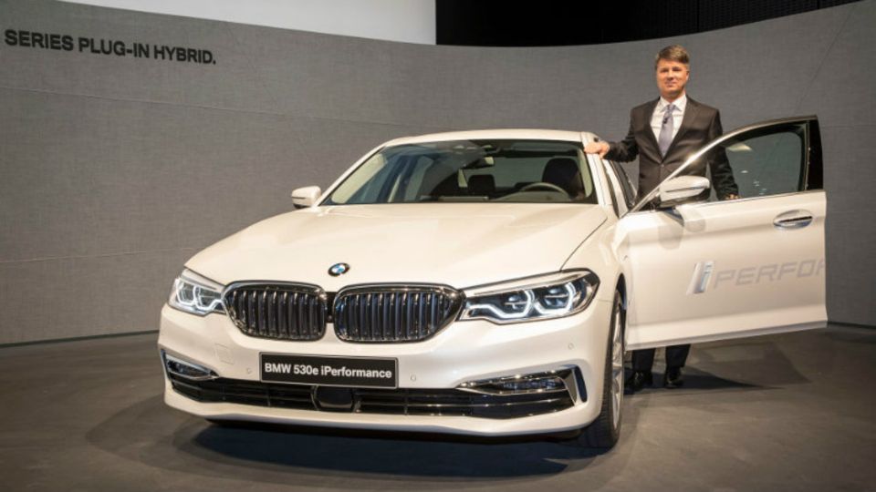BMW-Chef Krüger mit einem 5er BMW mit Hybridantrieb