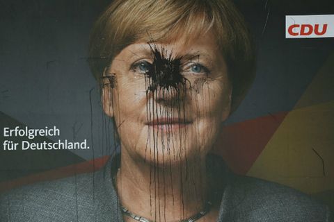 Ein von einem Fabrbbeutel getroffenes Wahlplakat von Angel Merkel