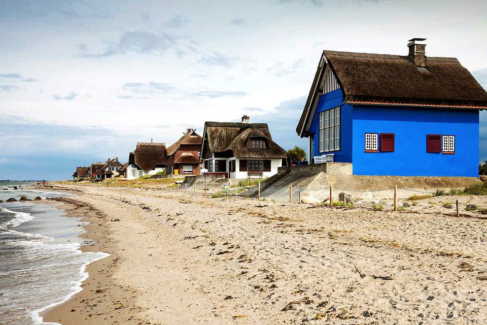 Reetgedeckte Schönheiten: Die Ferienhäuser auf der Halbinsel Graswarder residieren am Strand