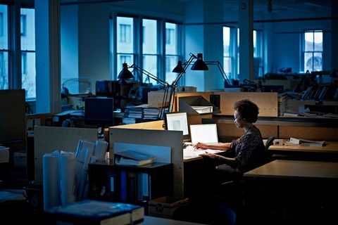Businesswoman examining documents at desk at night