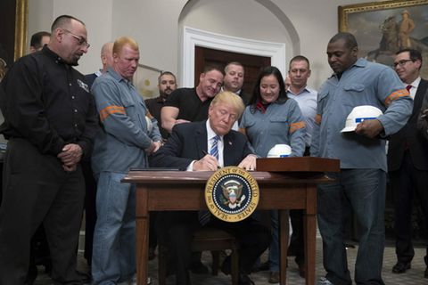 Umringt von amerikanischen Stahlarbeitern unterzeichnet US-Präsident Trump das Dekret zur Verhängung von Strafzöllen auf Stahl- und Aluminiumimporte