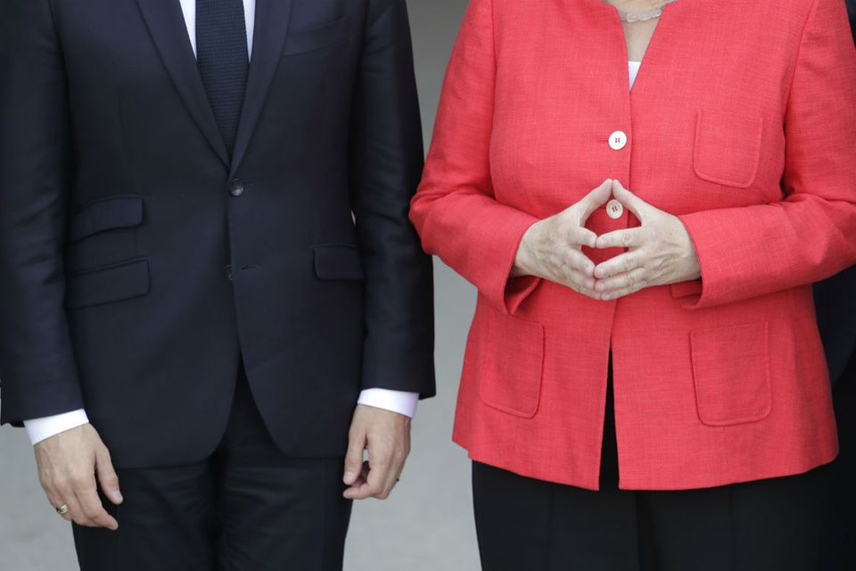 Frankreichs Präsident Macron lässt die Arme hängen, während Bundeskanzlerin Merkel mit ihren Händen die für sie so typische Raute formt