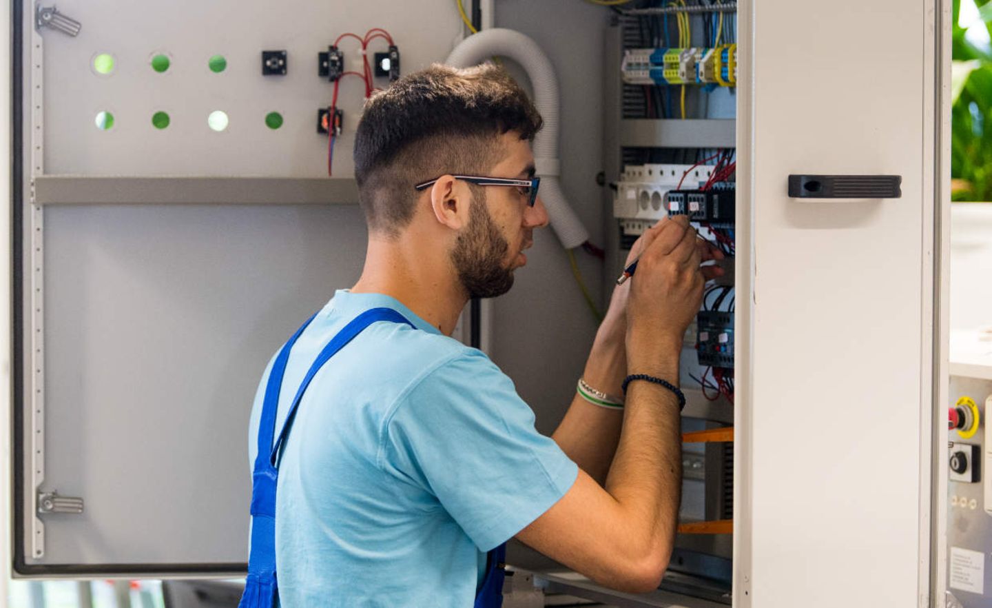 Der 23-jährige Azzam aus Syrien arbeitet im Ausbildungszentrum der Siemens Professional Education an der Verdrahtung eines Schaltschranks
