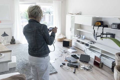 Eine Frau fotografiert die Spuren eines Einbruchs