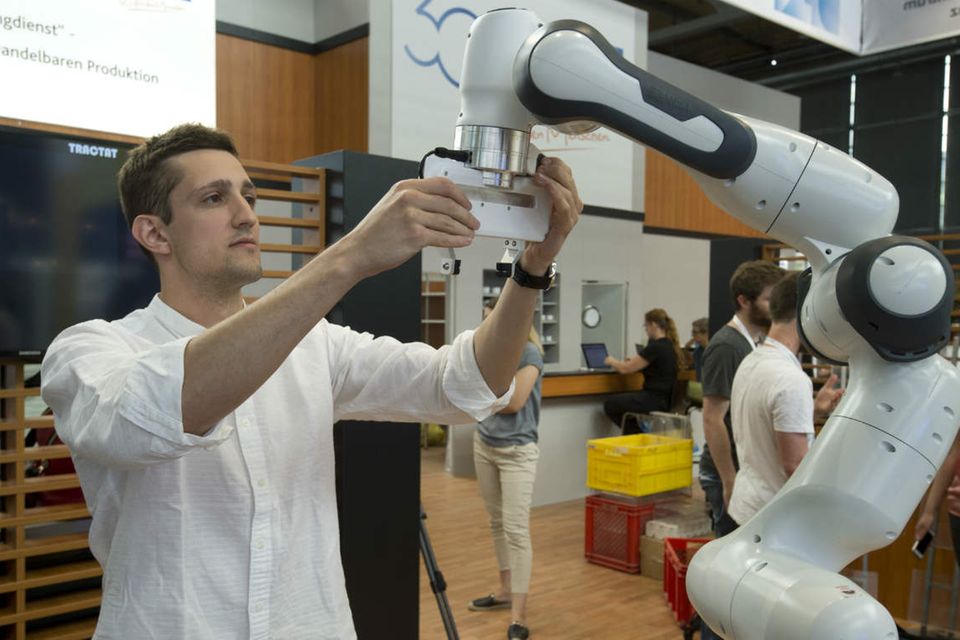 Ein Mitarbeiter des Deutschen Forschungszentrums fuer künstliche Intelligenz lehrt einen Roboterarm, selbstständig eine Bewegung auszuführen