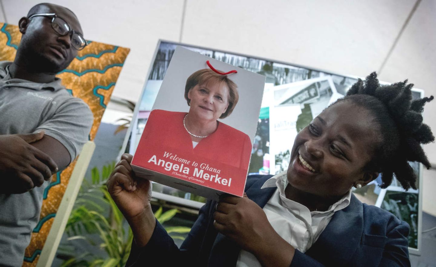 Henrietta Adjetey vom Start-up „Brand E“ zeigt eine Papiertüte mit dem Bild von Bundeskanzlerin Angela Merkel. Ghana ist die zweite Station der dreitägigen Afrikareise der Kanzlerin