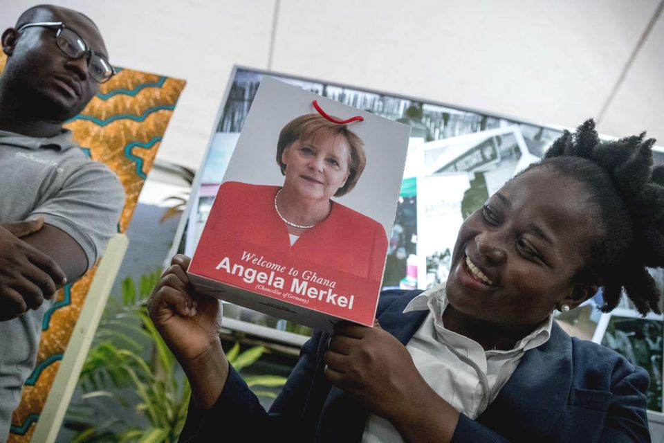 Henrietta Adjetey vom Start-up „Brand E“ zeigt eine Papiertüte mit dem Bild von Bundeskanzlerin Angela Merkel. Ghana ist die zweite Station der dreitägigen Afrikareise der Kanzlerin