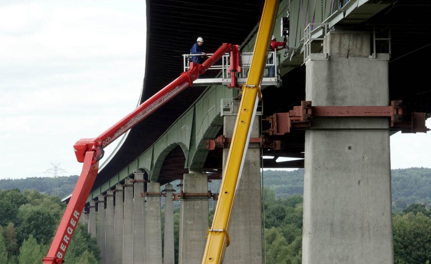 Kräne stehen an einem Pfeiler der maroden Rader Hochbrücke über den Nord-Ostsee-Kanal. Die Brücke wird derzeit mit Stahlplatten verstärkt. Ende Oktober soll die Verstärkungsmaßnahme abgeschlossen sein.