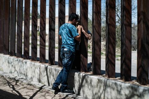 Ein Mann und eine Frau unterhalten sich durch den Grenzzaun, der die mexikanische Hälfte der Stadt Nogales von der amerikanischen trennt