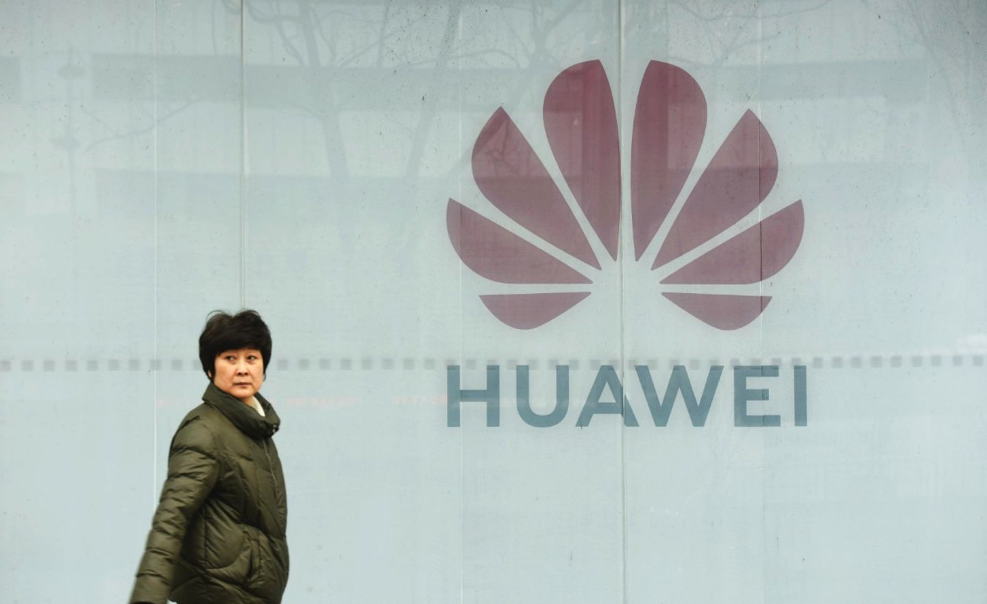 Eine Frau geht an einem Huawei-Shop in China vorbei