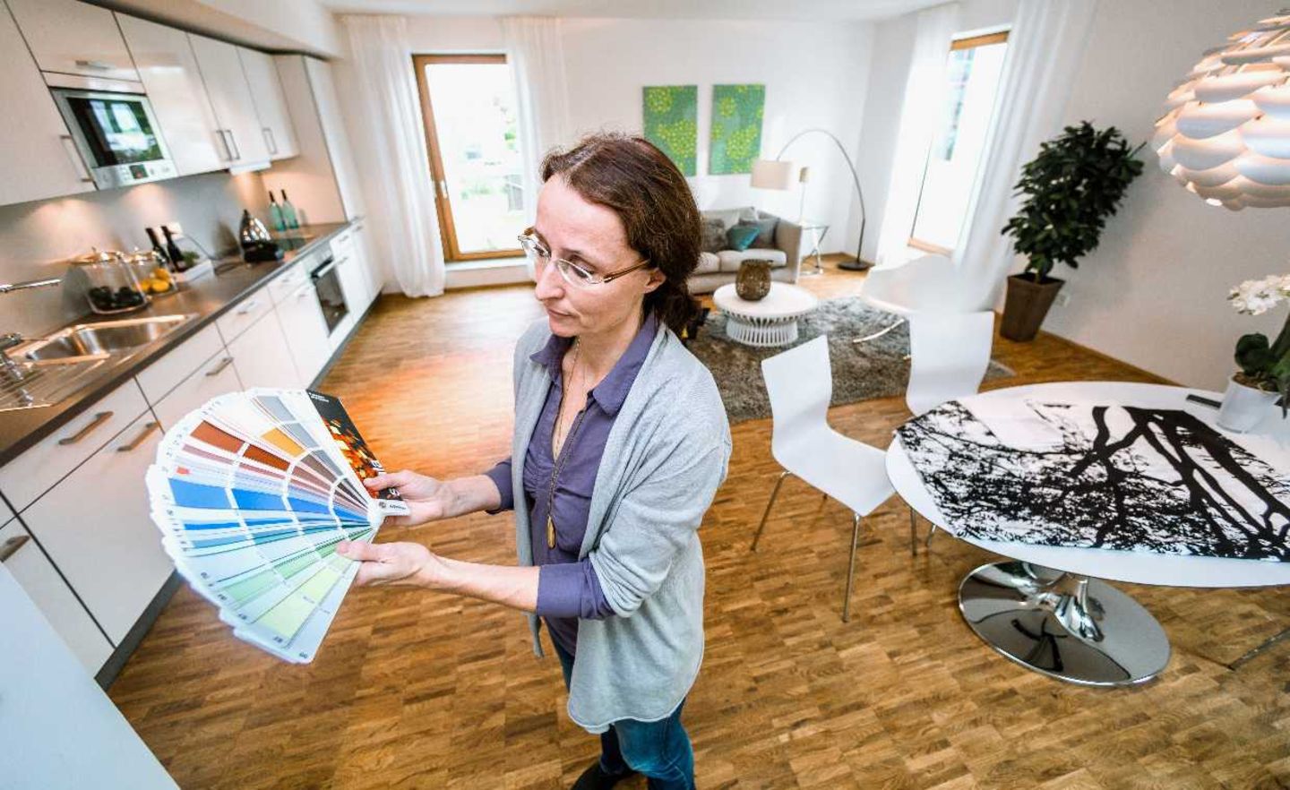Home Staging: Eine Inneneinrichterin putzt eine Wohnung heraus, damit sie sich besser verkaufen lässt