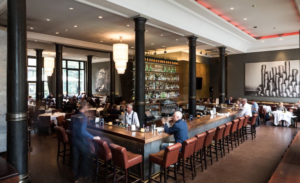 Die Bank, Hamburg In den Hohen Bleichen befindet sich Die Bank in bester Gesellschaft. Das Interieur ist klassisch, aber nicht steif. Schnell werden Sie den langen Bartresen als wahre Attraktion enttarnen. Das zwanzigseitige Bar-Menü lässt keine Wünsche offen: Hier können Sie den Deal gebührend mit Champagner und frischen Austern zelebrieren oder bei Pommes, Bier und Shots entspannt ins Hamburger Nachtleben starten. Die schönen Worte “open end” verraten, dass die Nächte hier auch mal länger werden können.
Die Bank Brasserie & Bar | Hohe Bleichen 17, 20354 Hamburg | Montag – Samstag ab 11.30 Uhr
