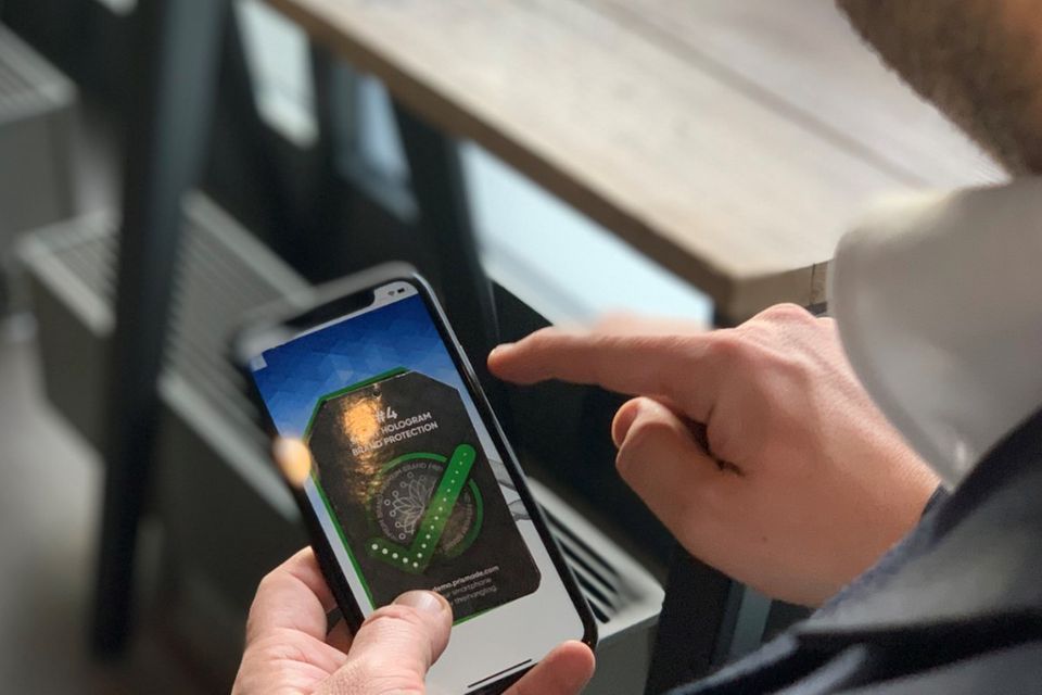 Um Produkte wie Medikamente oder hochwertige Modeaccessoires fälschungssicher und eindeutig identifizierbar zu machen, werden Produkte mit Bar- oder QR-Codes ausgestattet, die aber als sichtbares Element leicht imitiert werden kann. Um dieser Problematik entgegenzuwirken, entwickelt der Schreibwarenhersteller Edding ein digitales Wasserzeichen, den unsichtbaren QR-Code. Um den QR-Code mit Produktverpackung oder dem Etikett mit dem Smartphone auszulesen, ist ein physischer Kontakt nötig - über den berührungsempfindlichen Bildschirm kann die App die leitfähige Tinte erkennen. edding hat intensiv in Innovation investiert, um digitale Projekte voranzutreiben. Entwickelt hat das System ursprünglich das Chemnitzer Start-up Prismade, an dem Edding inzwischen beteiligt ist.