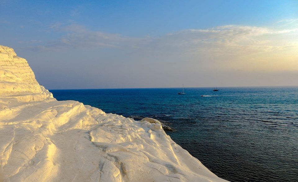 Blendend weiße Kalksteinfelsen vor dunkelblauen Wellen, die im Sonnenlicht glitzern. Die Scala dei Turchi in Sizilien ist mit ihren natürlichen Treppenstufen ein absoluter Besuchsmagnet! Der Ansturm ist sogar auf die permanente Präsenz auf Instagram zurückzuführen. Weil viele Instagramer ein gutes Fotomotiv wohl dem Naturschutz vorziehen, ist ein Teil des Felsens momentan gesperrt. Wir empfehlen: Genießen Sie die Scala dei Turchi doch einfach vom Strand aus. Ohne Menschen auf den Treppen wirkt die Szenerie sogar noch majestätischer!