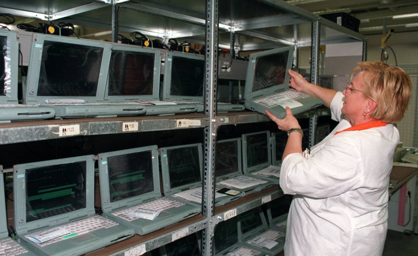 Eine Mitarbeiterin von Siemens Nixdorf - Geschäftsbereich PC - in Augsburg stellt einen Laptop für einen Testlauf ins Regal, aufgenommen Anfang April 1996. Im Dreischicht-Betrieb produzierten hier über 2000 Mitarbeiter täglich rund 4000 Computer.