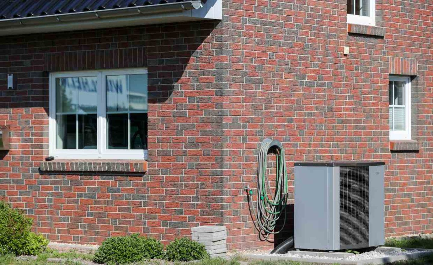 Eine Wärmepumpe steht vor einem Fertighaus