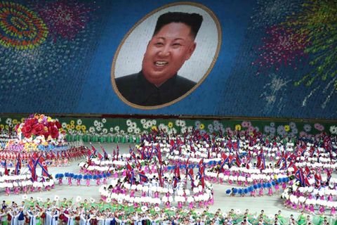 Darsteller halten bei einer Massenveranstaltung Karten hoch mit einem Porträt des nordkoreanischen Führers Kim Jong-un