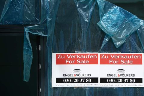 Schilder mit der Aufschrift "Zu Verkaufen - For Sale - Engel & Völkers" hängen an einem neu gebauten Wohnhaus in Berlin