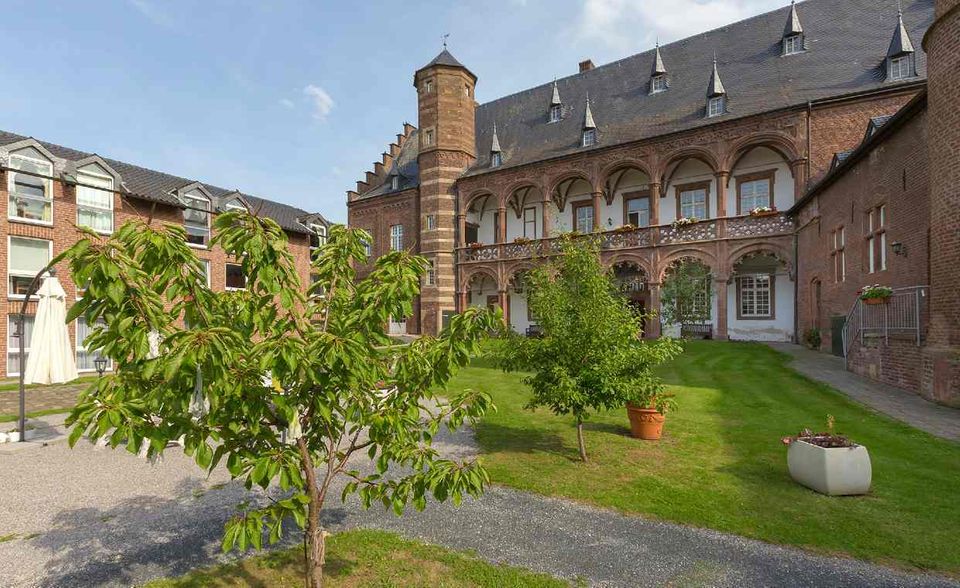 Am Rande des Nationalparks Eifel liegt im kleinen Örtchen Binsfeld eine geschichtsträchtige Seniorenresidenz: die Burg Binsfeld. Erbaut wurde die Wasserburg im Jahr 1533, sie diente zunächst als Herrenhaus. Heute leben dort bis zu 109 Senioren. Im Gegensatz zu vielen anderen Edel-Residenzen können die Bewohner von Burg Binsfeld auch vollstationäre Pflege buchen. Geschichtsfans mit Pflegegrad eins können für 2581 Euro ein Einzelzimmer beziehen und sich ganz als Burgherren und Burgfräuleins fühlen. Weil die Pflegekasse bei höheren Pflegegraden auch einen höheren Anteil an den Kosten übernimmt, zahlt man ab Grad zwei nur 2152 Euro.