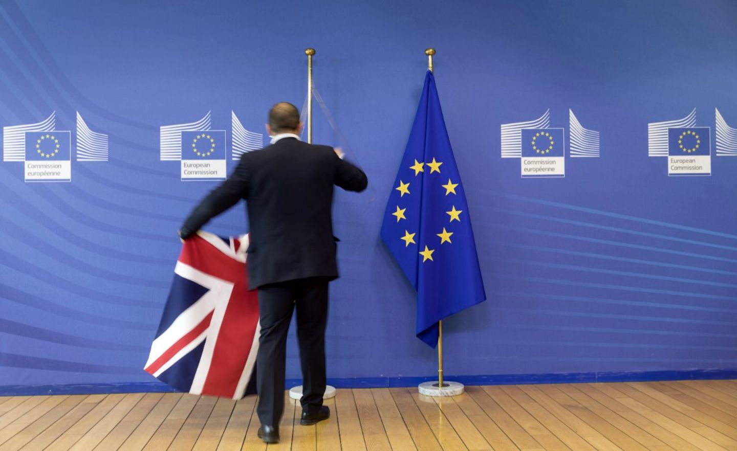 Ein Bediensteter entfernt den Union Jack und die EU-Flagge am VIP-Eingang des Berlaymont-Gebäudes
