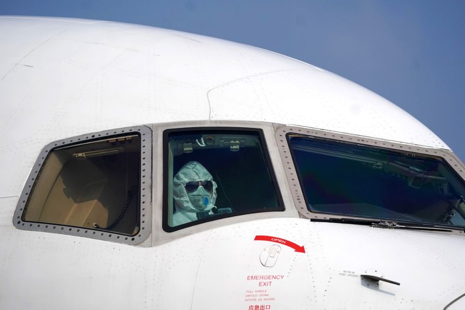 Sinnbild der Krise: Ein Pilot in Schutzkleidung parkt ein Flugzeug am internationalen Flughafen in Wuhan