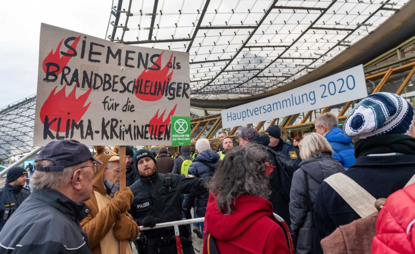 Vor der Halle der Siemens-Hauptversammlung demonstrieren Hunderte Umweltaktivisten und fordern einen Ausstieg aus dem Geschäft mit Kohle-, Öl- und Gaskraftwerken.