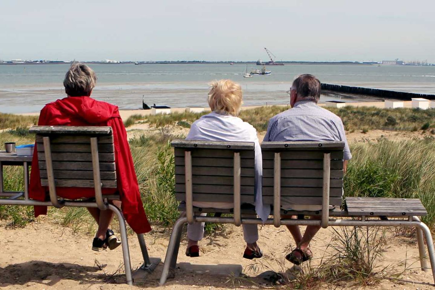 Rentner sitzen auf einer Bank und schauen aufs Meer