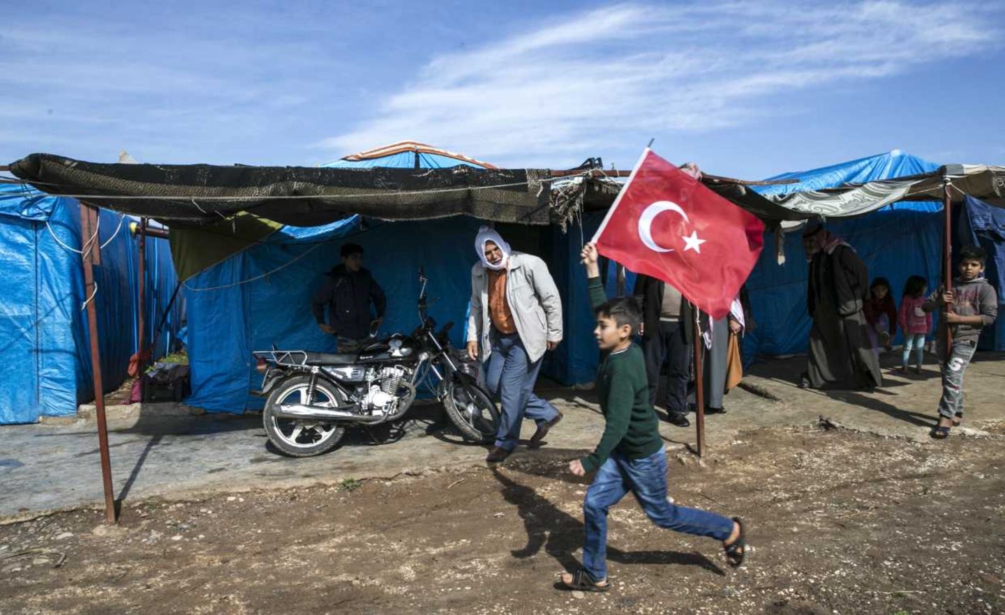 Ein Junge läuft mit einer türkischen Flagge durch ein Flüchtlingslager: Die Türkei hat mehr als 3,6 Millionen Flüchtlinge aufgenommen