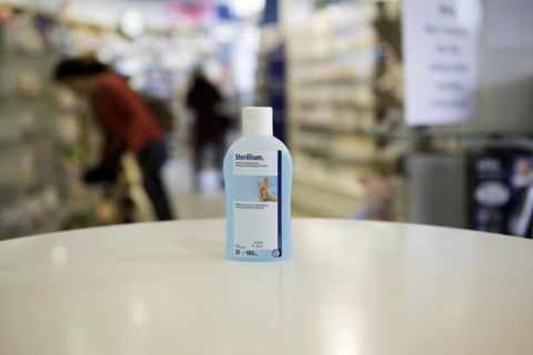 Eine Flasche Desinfektionsmittel steht auf einem Tisch in einer Apotheke