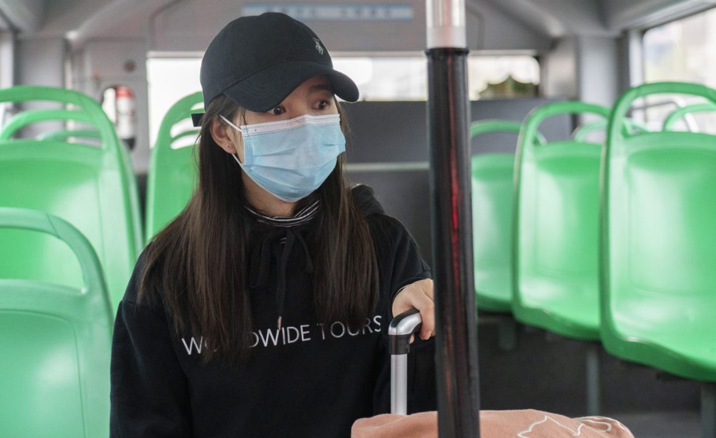 Eine Chinesin fährt in Wuhan mit dem Bus. Der öffentliche Nahverkehr war lange Zeit eingestellt