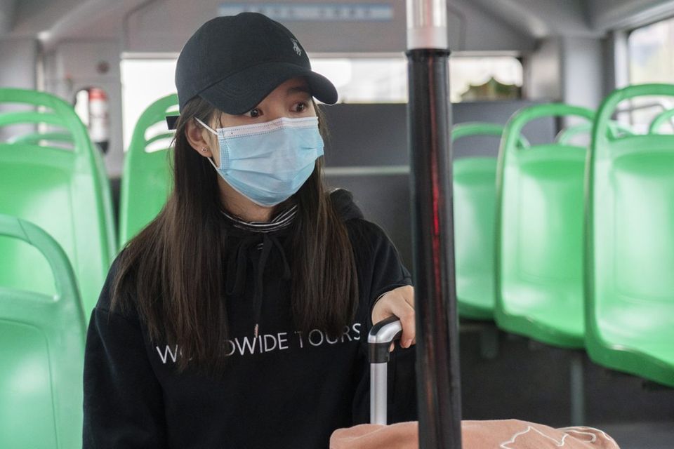 Eine Chinesin fährt in Wuhan mit dem Bus. Der öffentliche Nahverkehr war lange Zeit eingestellt