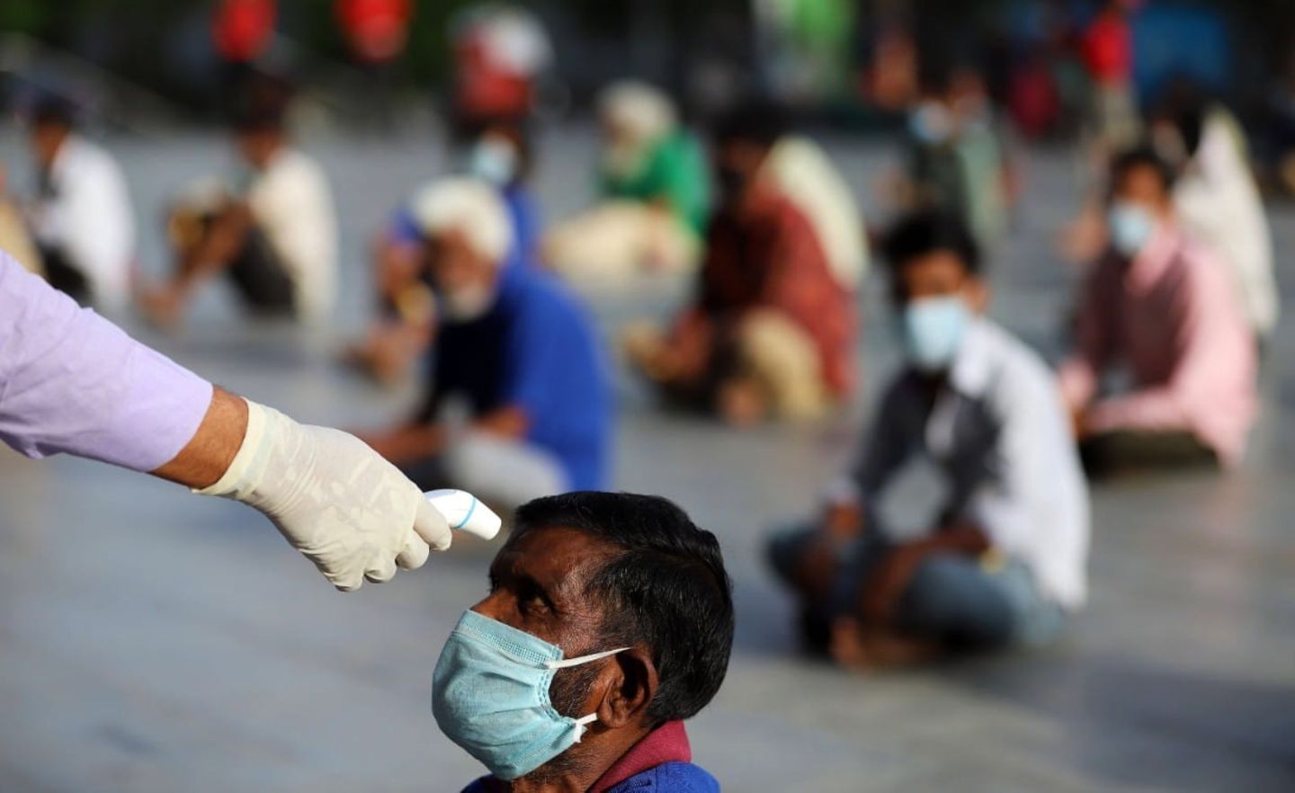 Ein Mann prüft bei einem Wohnungslosen die Körpertemperatur: Auch in Indien hat die Regierung einen Lockdown verfügt, um die Ausbreitung des Coronavirus zu verhindern
