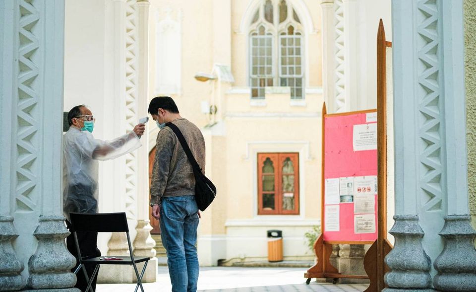 Vor dem Betreten einer Kirche wird die Körpertemperatur gemessen. Schutzmasken sind ohnehin Pflicht