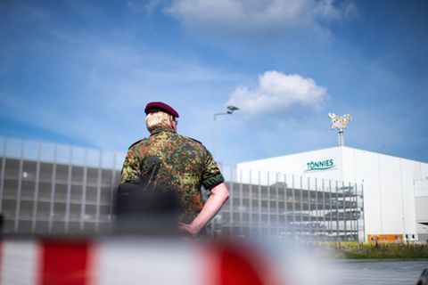 Um die Krise bei Tönnies in Rheda-Wiedenbrück in den Griff zu bekommen, hilft auch die Bundeswehr. Ein Soldat steht vor dem Werksgelände