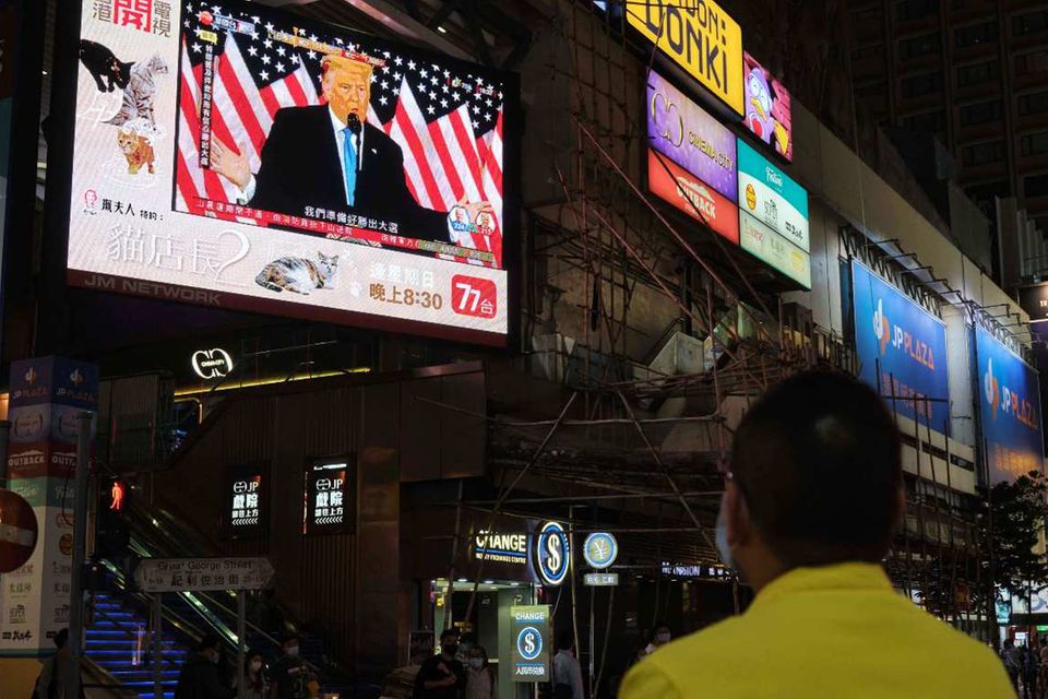 Ein Mann in Hongkong schaut sich auf einem Großbildschirm ein Statement von Donald Trump an