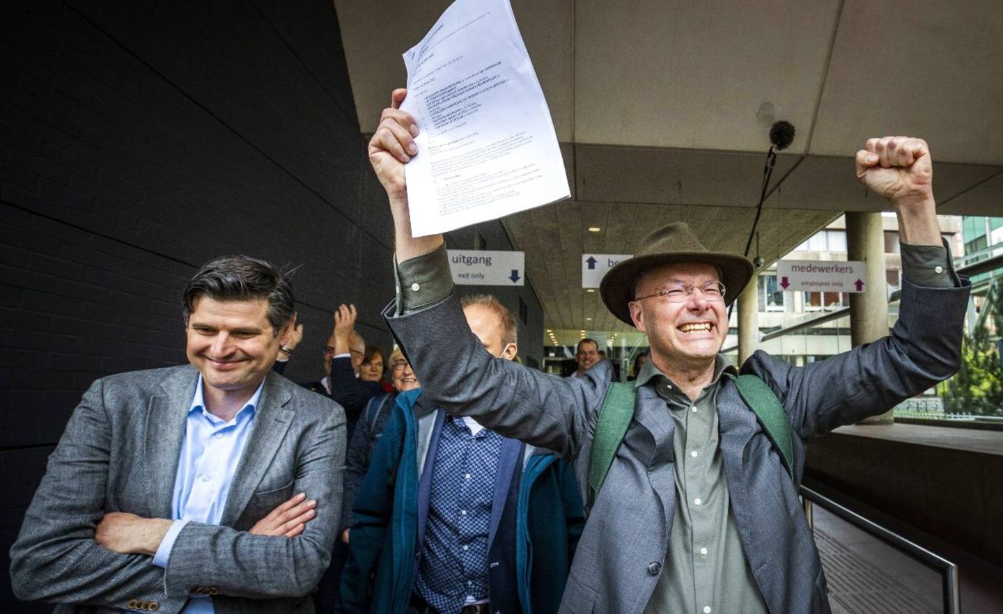 Rechtsanwalt Roger Cox und Donald Pols von der niederländischen Umweltorganisation Milieudefensie verlassen sichtlich erfreut das Gerichtsgebäude in Den Haag. Die Richter haben im Klimaprozess gegen Royal Dutch Shell entschieden