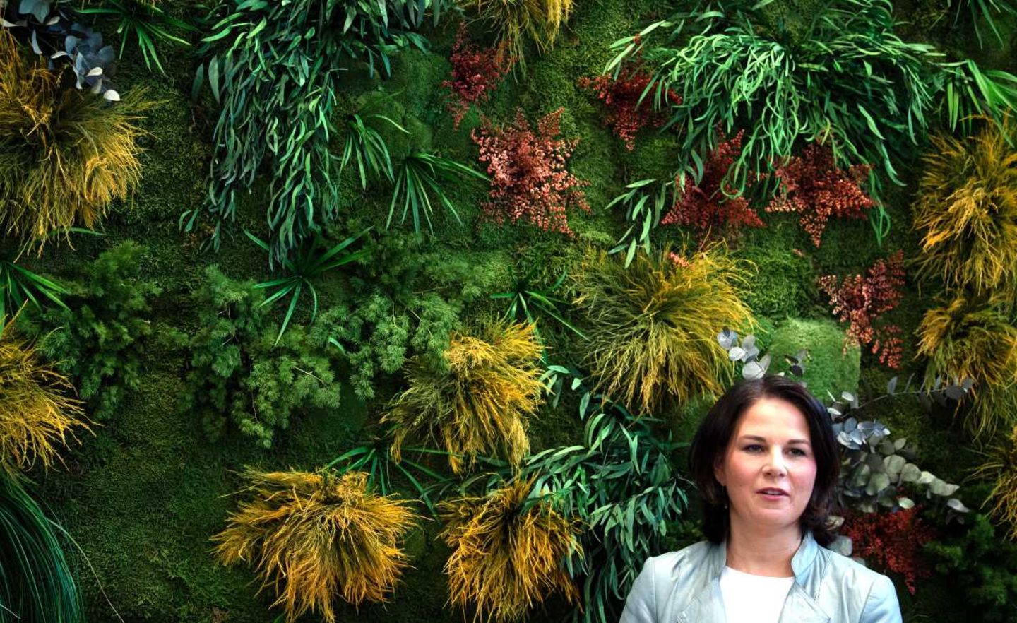 Annalena Baerbock steht beim Besuch des Start-ups Fond of vor einer Mooswand