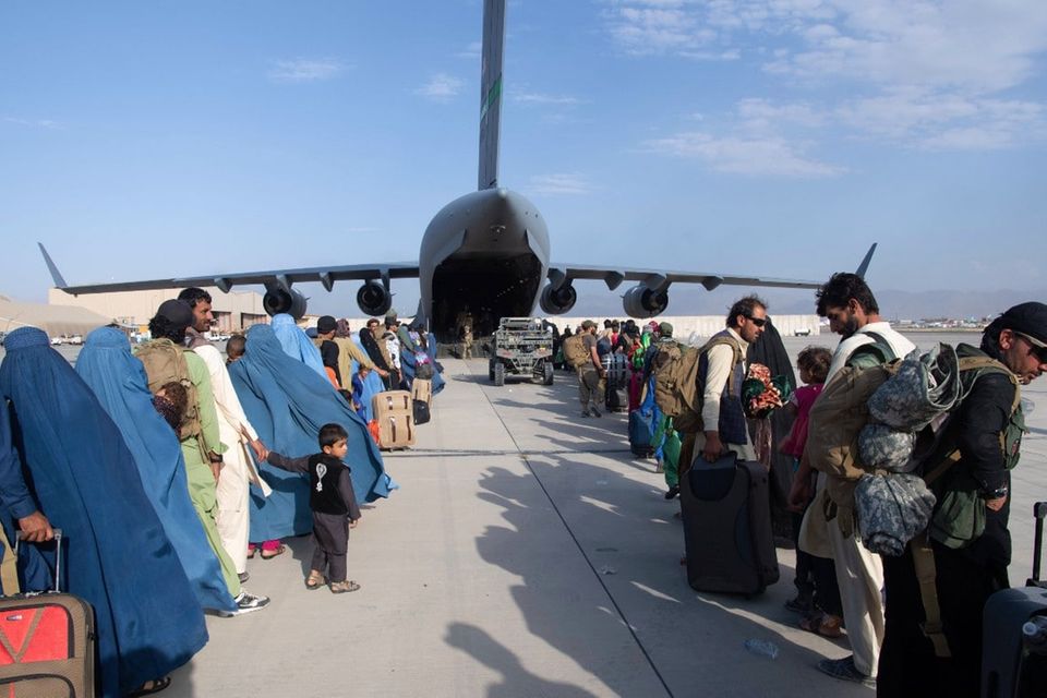 Afghanische Flüchtlinge warten vor einem Militärtransportflugzeug, das sie in Sicherheit bringen soll