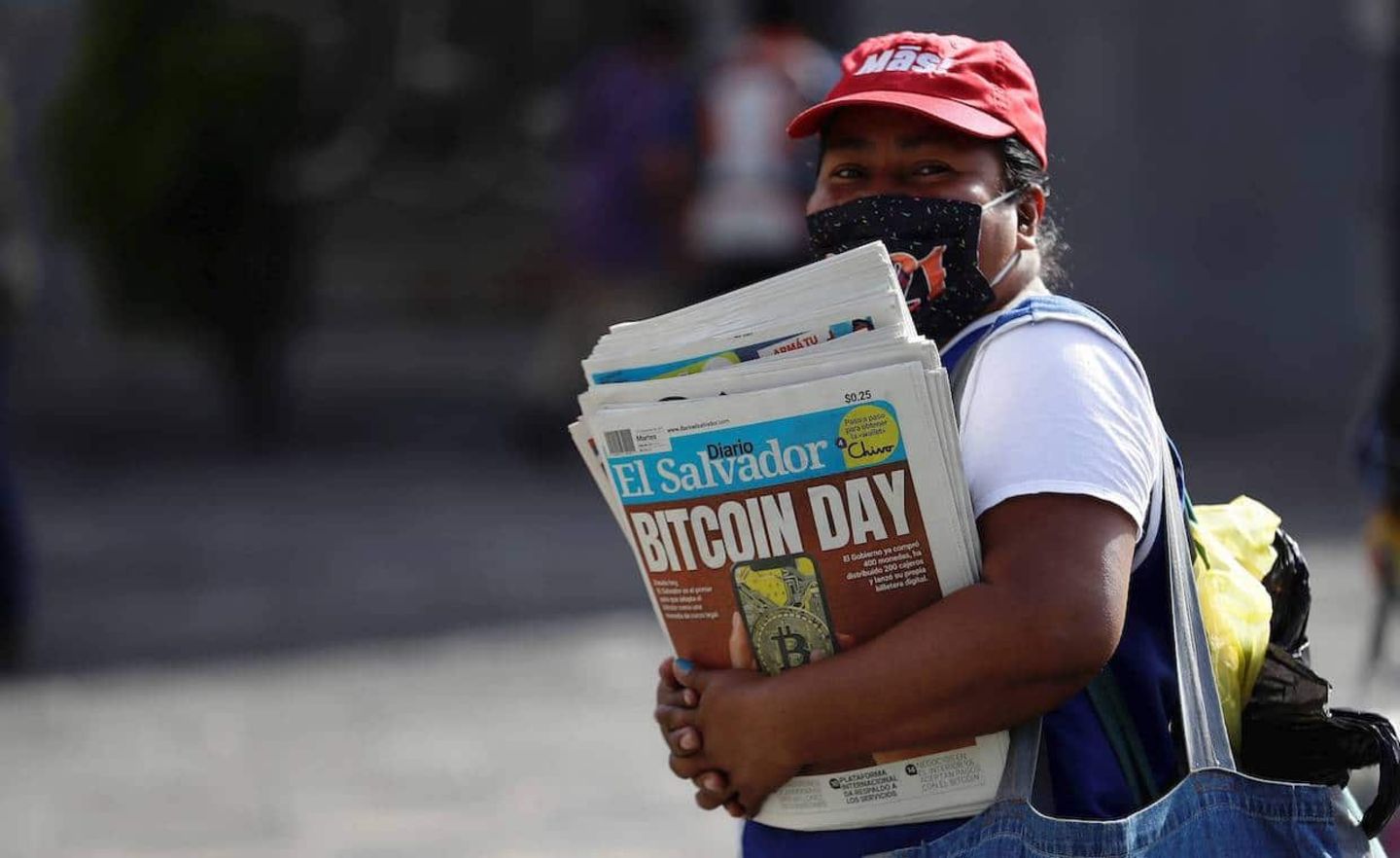 Eine Frau verkauft Zeitungen, die den Start von Bitcoin in El Salvador verkünden, September 2021